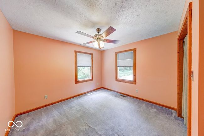 carpeted spare room with a ceiling fan and a textured ceiling | Image 39