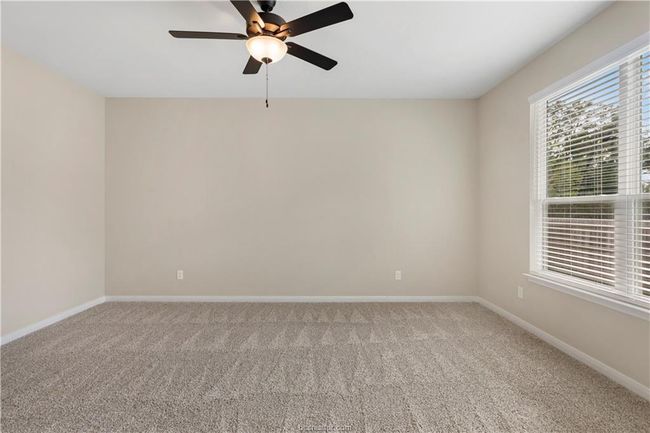 Carpeted room with ceiling fan and baseboards | Image 13