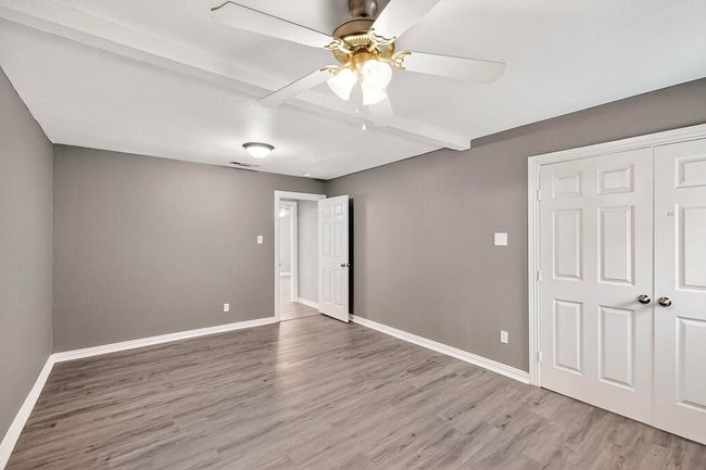 Unfurnished bedroom with light wood-style floors, a closet, beam ceiling, and a ceiling fan | Image 17