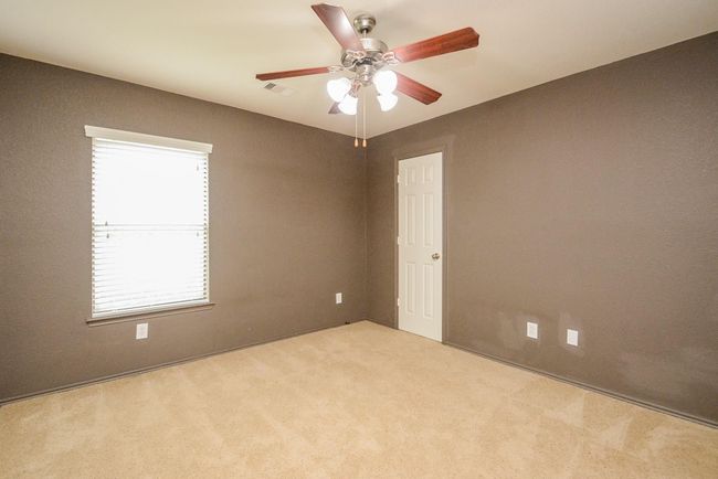 This secondary bedroomfeatures plush carpeting & aceiling fan for comfort. | Image 21