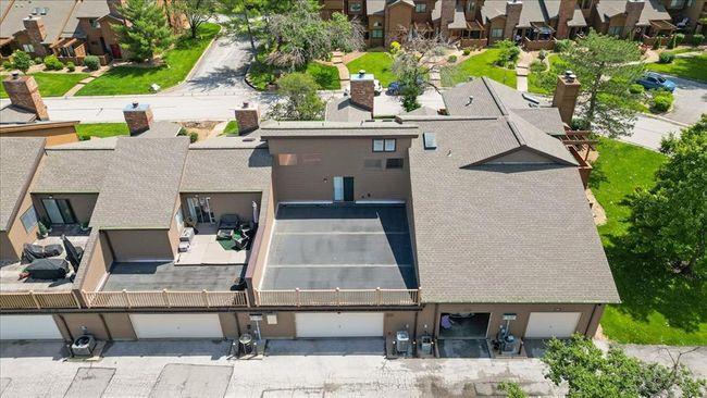 Rear view of house with stairs, a chimney, and a shingled roof | Image 24
