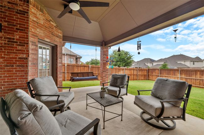 Fenced backyard featuring a patio area, ceiling fan, and outdoor lounge area | Image 36
