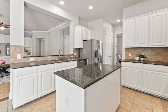 Kitchen featuring stainless steel appliances, dark stone counters, a kitchen island, tasteful backsplash, and recessed lighting | Image 13
