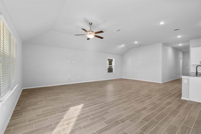 Unfurnished living room featuring visible vents, ceiling fan, vaulted ceiling, and recessed lighting | Image 11