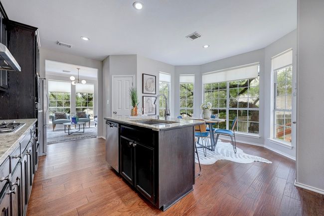 Kitchen featuring a sink, appliances with stainless steel finishes, a kitchen island with sink, dark wood-type flooring, and recessed lighting | Image 18