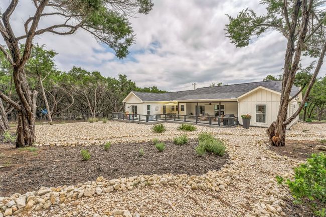 Rear view of property featuring board and batten siding, a patio, and a deck. | Image 28