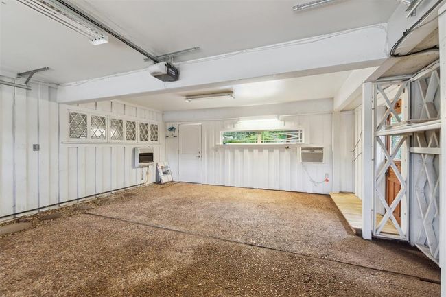 Garage featuring a wall mounted AC and a garage door opener | Image 34