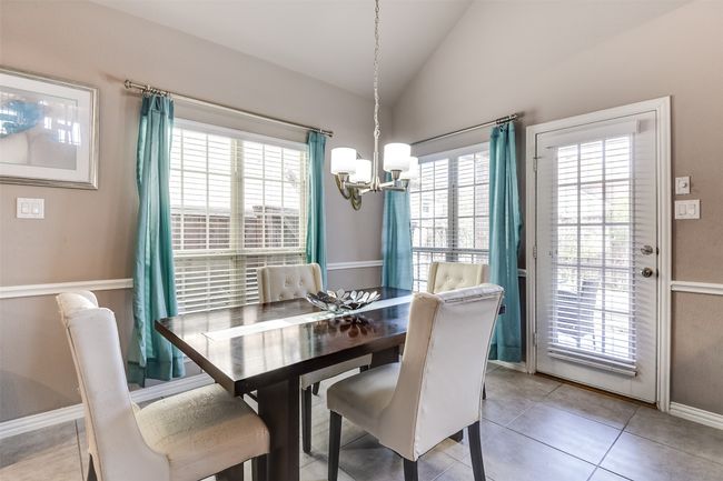 Tiled dining area featuring an inviting chandelier and lofted ceiling | Image 14