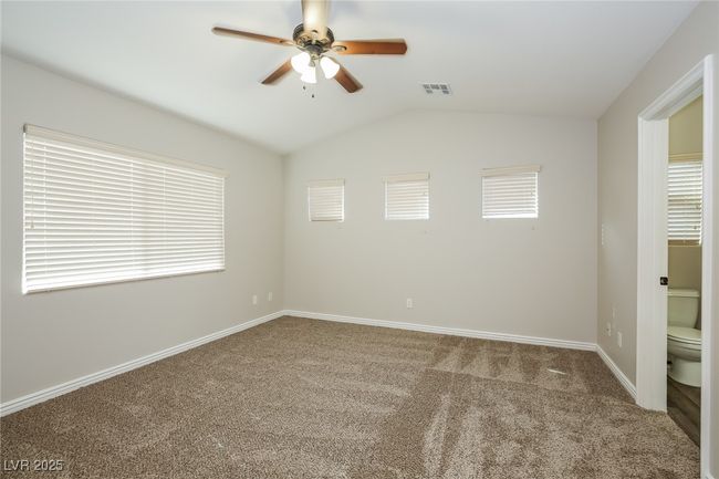 Spare room with carpet flooring, ceiling fan, visible vents, baseboards, and lofted ceiling | Image 8
