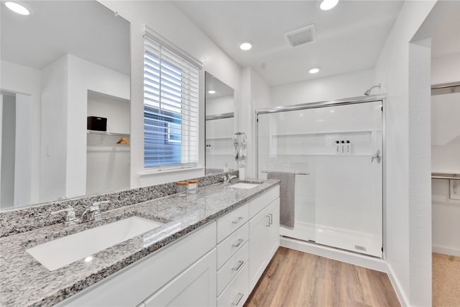 Bathroom with a shower stall, visible vents, a sink, and wood finished floors | Image 19