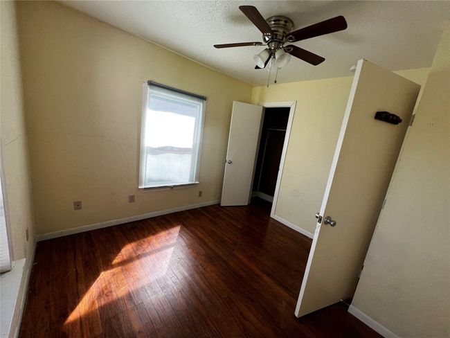 Unfurnished bedroom featuring wood finished floors, baseboards, and a ceiling fan | Image 6