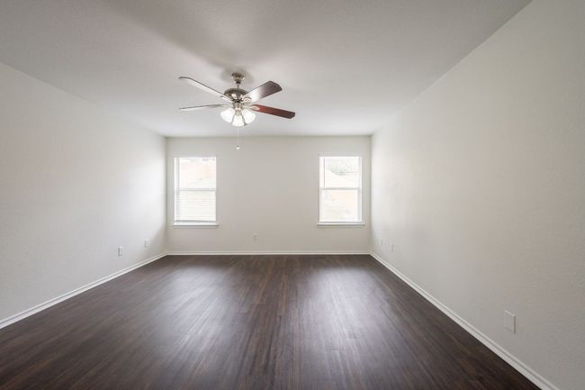 Empty room with plenty of natural light, ceiling fan, and dark wood-style floors | Image 16