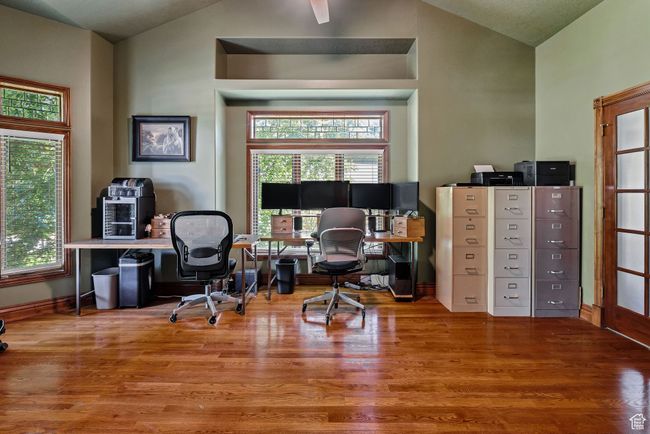 Office space featuring vaulted ceiling, wood finished floors, and plenty of natural light | Image 29
