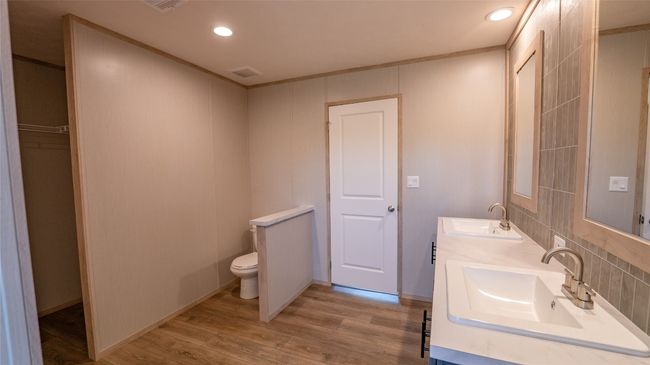 Bathroom with double vanity, wood finished floors, recessed lighting, and backsplash | Image 29