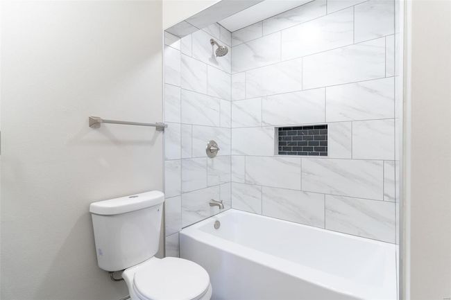 Bathroom featuring toilet and tiled shower / bath | Image 26