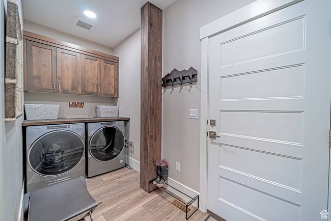 Laundry room featuring washer and clothes dryer, cabinet space, light wood finished floors, and baseboards | Image 29