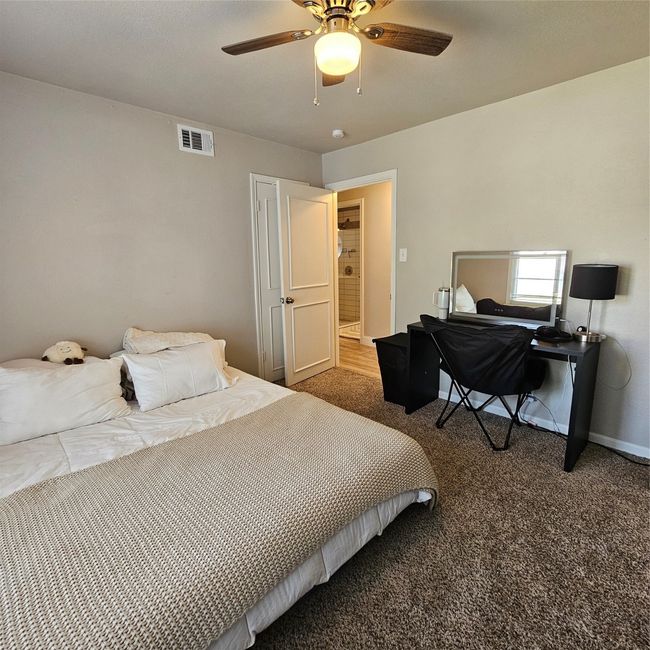 Beautifully lit carpeted bedroom featuring ceiling fan | Image 17