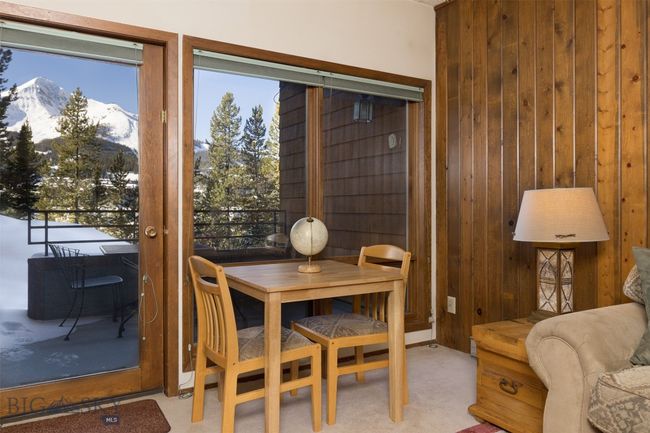 Dining space with a mountain view, light colored carpet, and wood walls | Image 20