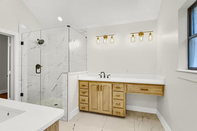 Full bathroom with marble look tile flooring, a marble finish shower, baseboards, and recessed lighting | Image 14