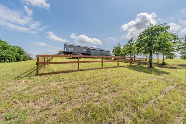 View of yard featuring a pole building, a view of countryside, and an outbuilding | Image 12