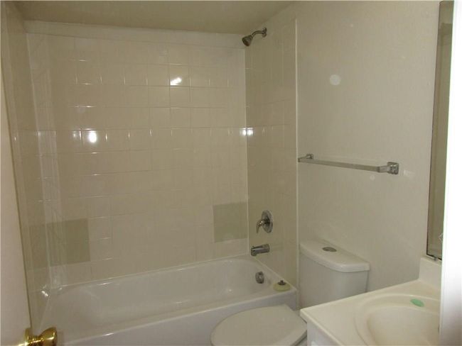 Full bathroom with vanity, tiled shower / bath combo, and toilet | Image 9