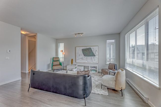 Living area featuring a baseboard radiator and wood finished floors | Image 9
