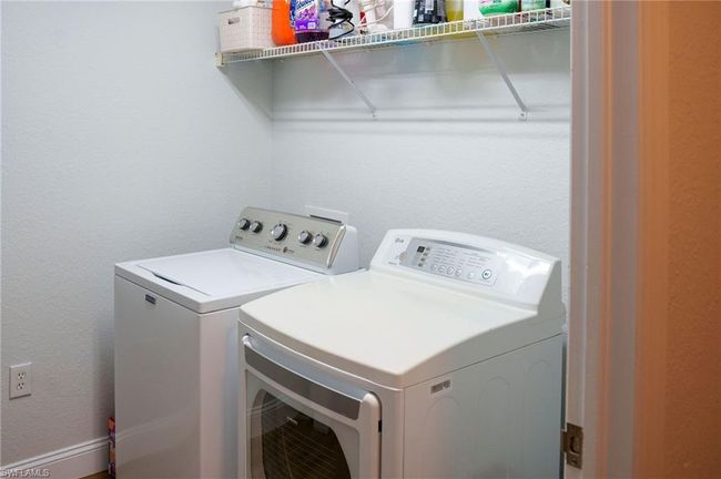 Washroom with laundry area, separate washer and dryer, and a textured wall | Image 24