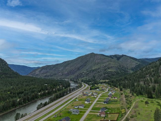 View of mountain backdrop with a heavily wooded area and a nearby body of water | Image 52