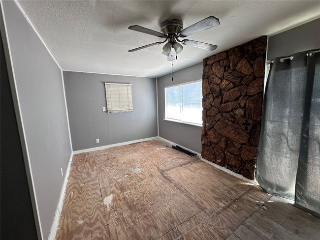 Spare room with a textured ceiling, a ceiling fan, and baseboards | Image 13