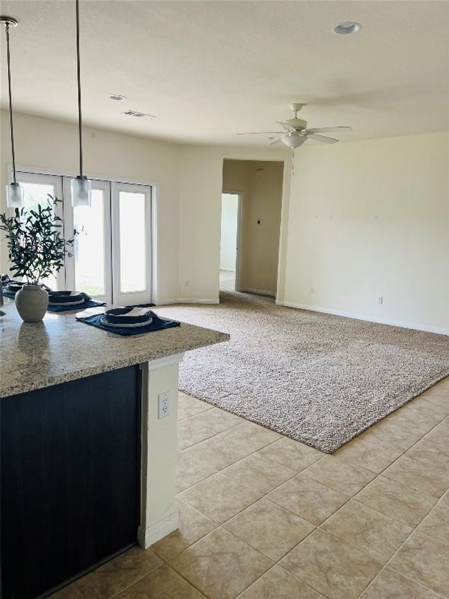 View to Living Room and kitchen island that accommodates 4-5 barstools is ready for your family and friends to gather in! | Image 5