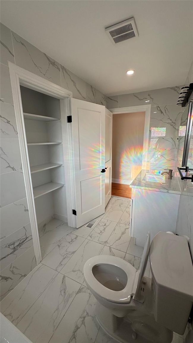 Bathroom featuring marble look tiles and recessed lighting | Image 5