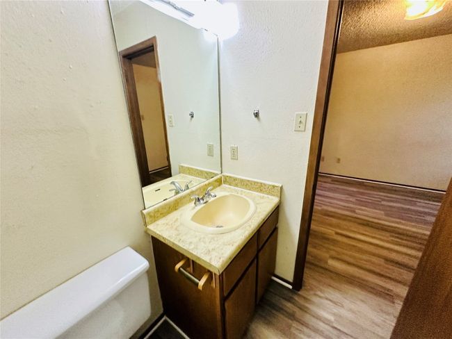Bathroom with a textured wall, wood finished floors, vanity, and a textured ceiling | Image 25