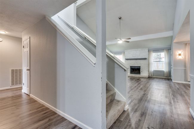 Stairs featuring ceiling fan, a fireplace, and hardwood / wood-style flooring | Image 5