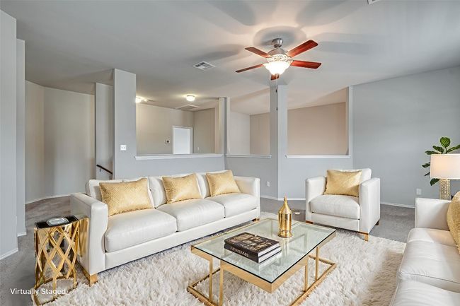 Carpeted living room featuring a ceiling fan and baseboards | Image 16