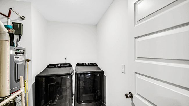 laundry room featuring washer and clothes dryer and electric water heater | Image 28