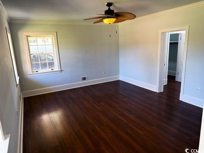 Unfurnished room featuring ceiling fan, dark hardwood / wood-style floors, and crown molding | Image 14