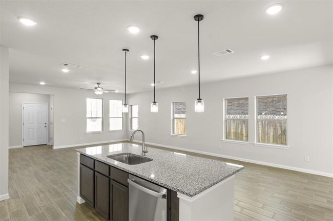 Kitchen with open floor plan, a ceiling fan, visible vents, stainless steel dishwasher, and a sink | Image 17
