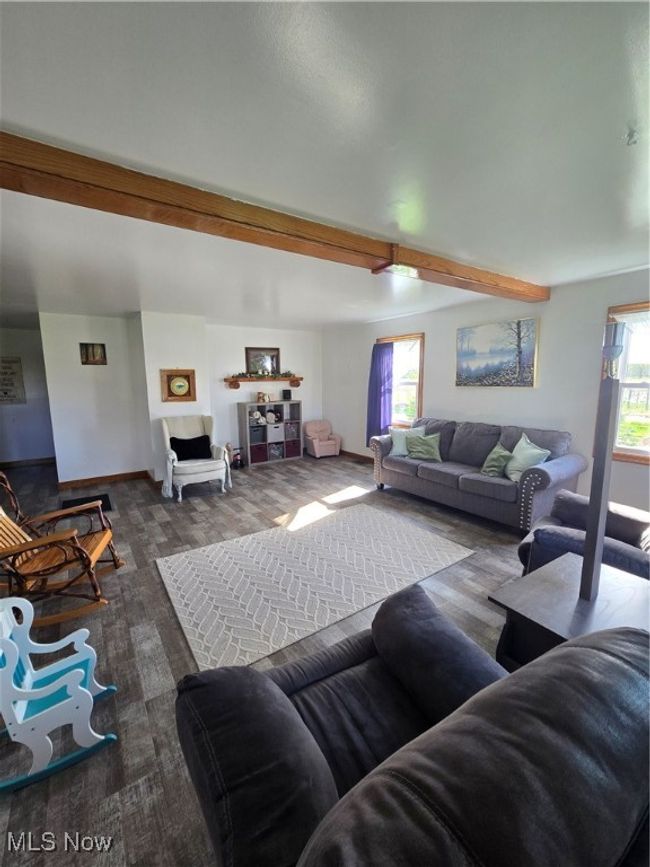 Living room with wood finished floors, a healthy amount of sunlight, baseboards, and beam ceiling | Image 6