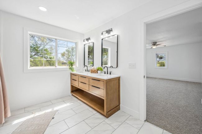 Bathroom featuring double vanity, marble finish floor, a sink, and a ceiling fan | Image 22