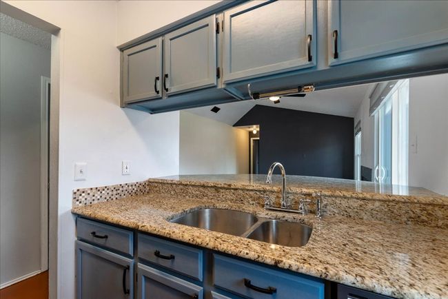Kitchen with a sink, light stone countertops, and blue cabinetry | Image 4