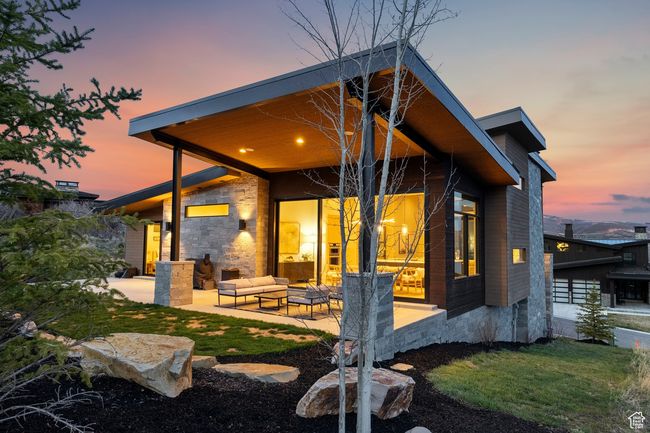 Back of house with an outdoor living space, stone siding, and a patio | Image 12