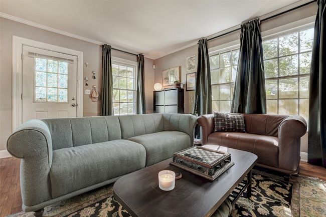 Living room with baseboards, crown molding, and wood finished floors | Image 7
