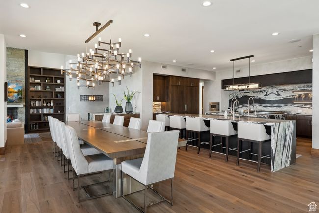 Dining space with wood finished floors, recessed lighting, a chandelier, and built in shelves | Image 10