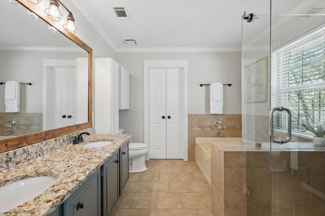 Full bath with a garden tub, double vanity, a shower stall, crown molding, and tile patterned flooring | Image 18