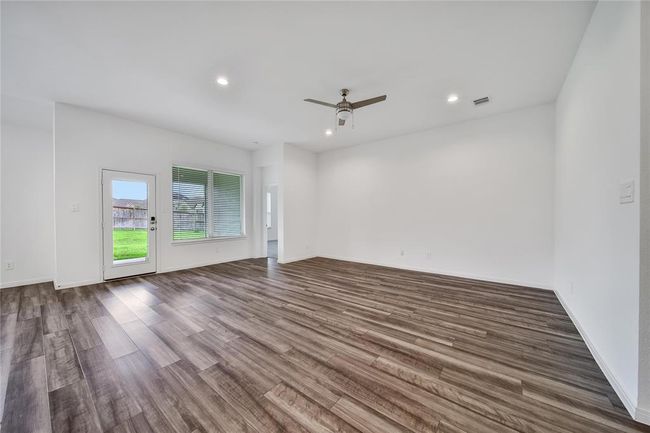 Recessed lighting, upgraded ceiling fan, high ceilings, and vinyl plank flooring make the family living area the perfect space. | Image 22