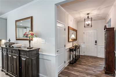 Foyer entrance featuring 9ft ceilings, crown molding, wainscoting, elegant chandelier, LVP flooring | Image 2