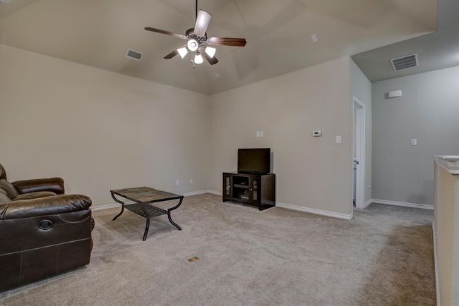 Living area featuring a ceiling fan, light colored carpet, and lofted ceiling | Image 29