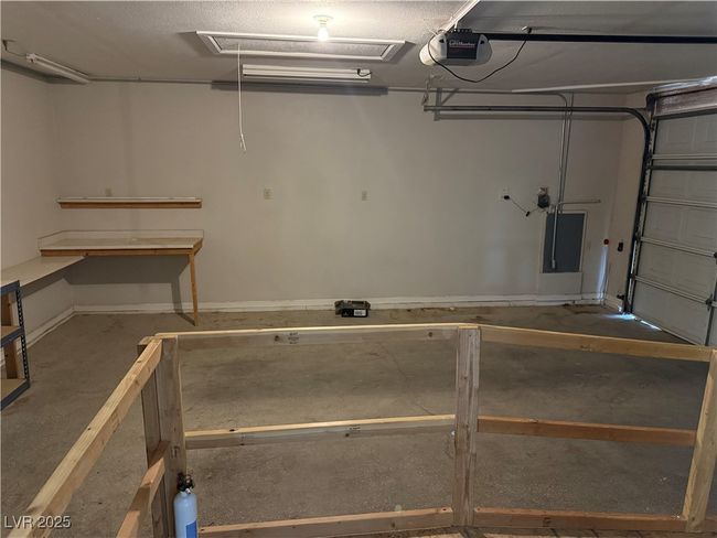 Garage with a garage door opener, electric panel, and baseboards | Image 23