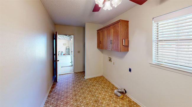 Washroom with baseboards, ceiling fan, hookup for a washing machine, hookup for an electric dryer, and a textured ceiling | Image 6