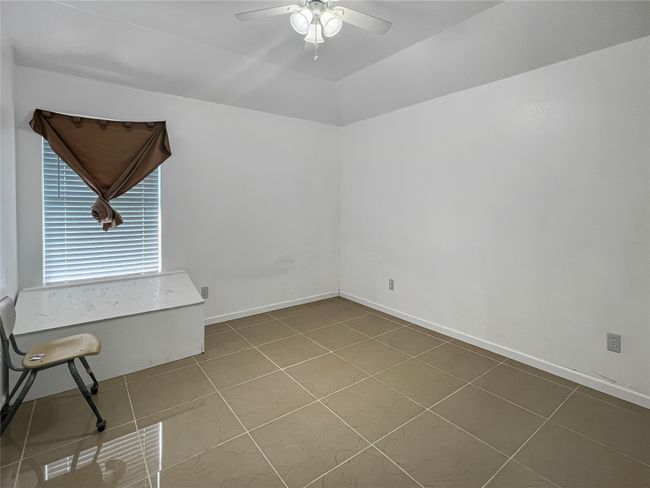 Tiled spare room featuring a ceiling fan and baseboards | Image 10